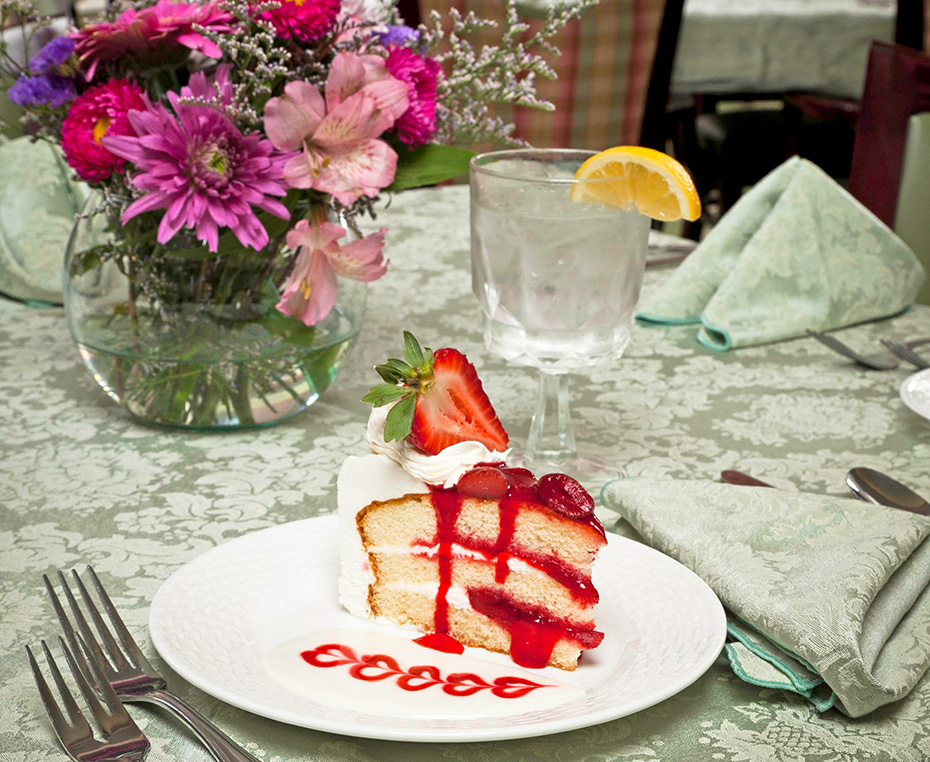 a slice of strawberry cake in the dining room