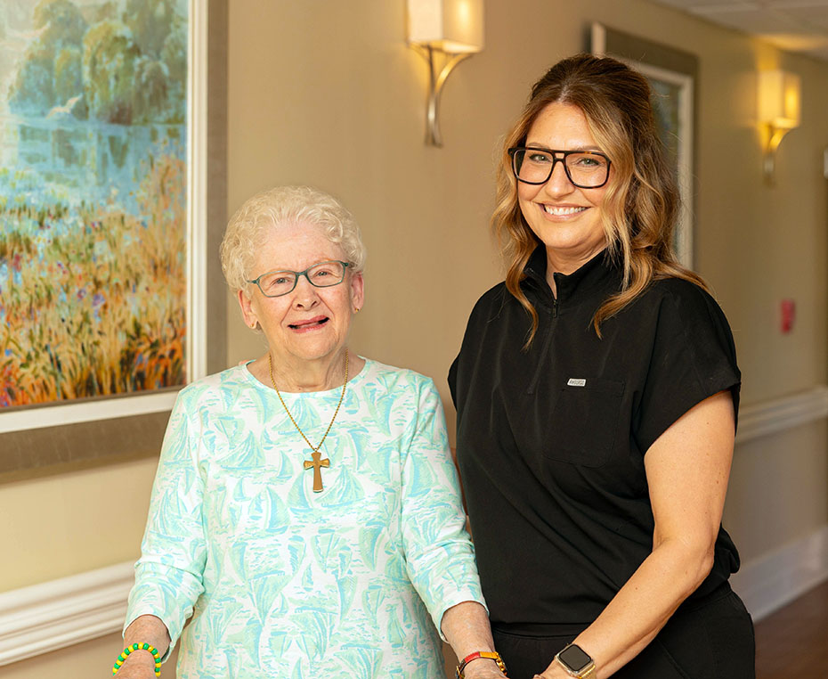 therapy director with resident in hallway